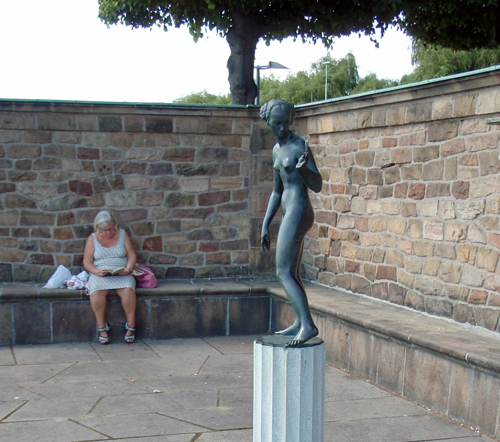 A middle aged woman is reading in Stockholm City Hall Park